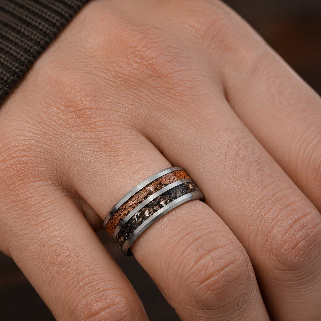 A close-up of a hand wearing a silver band ring with inlaid natural wood and dark textured strips.