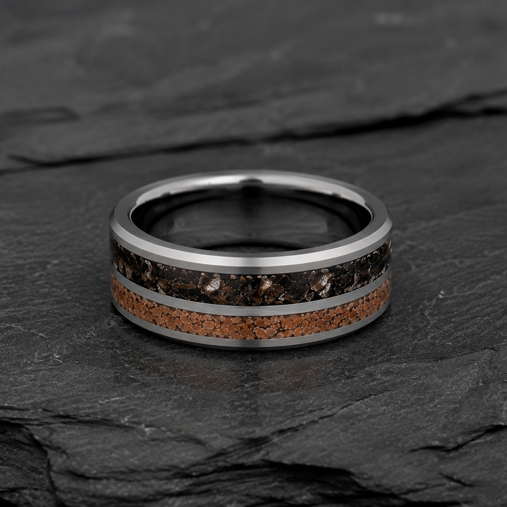 A silver-toned ring band featuring a dark brown and black wood grain inlay on one side and a textured orange-brown stone inlay on the other, displayed on a dark slate surface.
